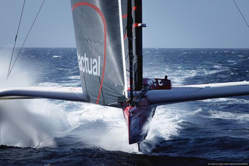 Trimaran Actual Ultim 4 pędzący na foilach w bryzgach wody