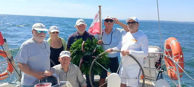Załoga jachtu Scorpio z wieńcem w kokpicie przy kole sterowym