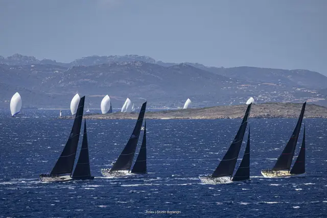 Flota maxi jachtów na trasie regat, w tle wyspy archipelagu La Maddalena