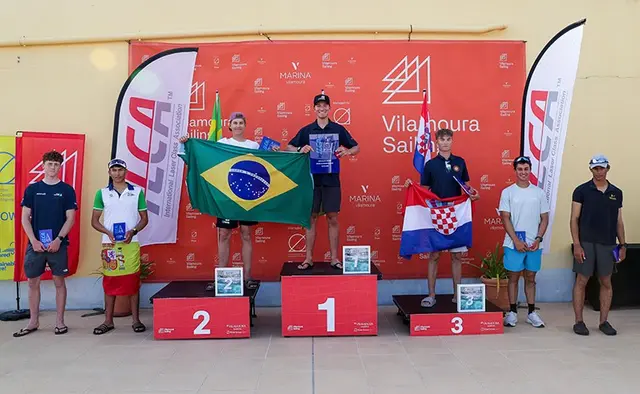 Podium mistrzostw świata ILCA 6 mężczyzn z flagami Brazylii i Chorwacji, obok pozostali wyróżnieni zawodnicy