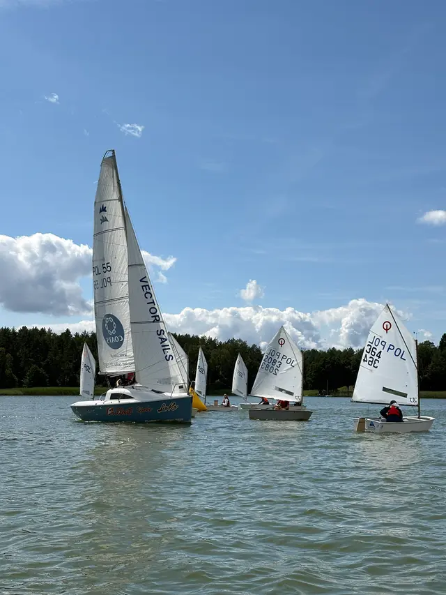 Jacht klasy OPEN i Optimisty na wodzie podczas wyścigu