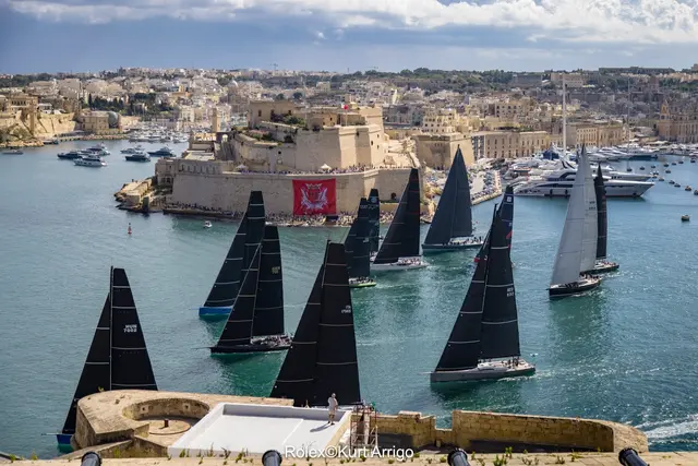 Jachty z czarnymi żaglami ruszają ze startu Rolex Middle Sea Race 2026 w Grand Harbour, w tle Fort St Angelo
