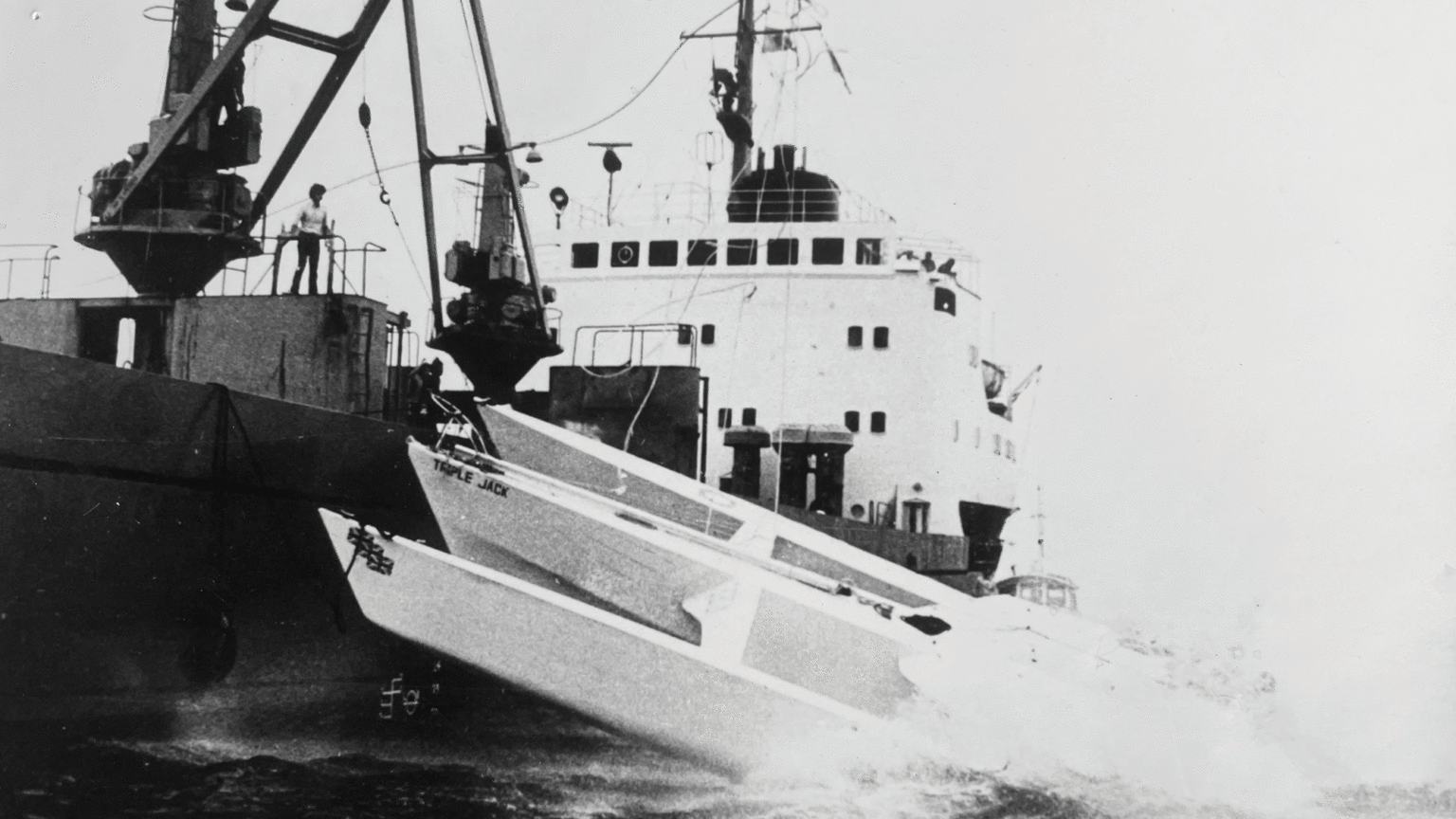 Triple Jack is towed across the 1981 TWOSTAR finish line in Newport, Rhode Island, by a freighter.