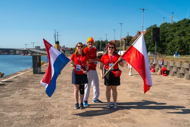Troje oficerów łącznikowych z flagami na nabrzeżu w Szczecinie